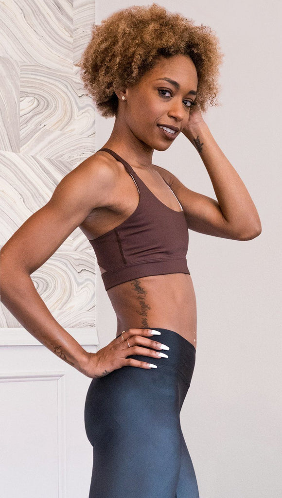 right side view of model wearing nude / mocha tone sports bra