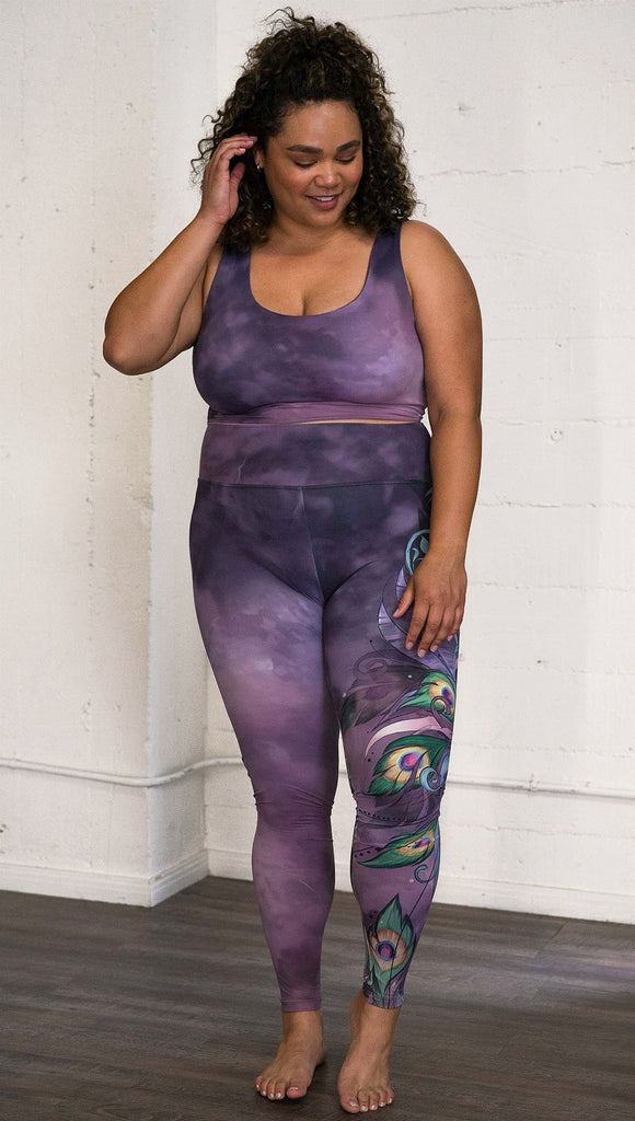 front view of model wearing peacock themed full length leggings