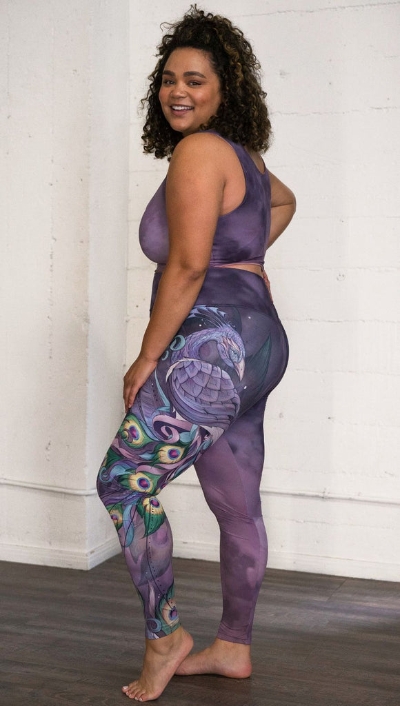 left side view of model wearing peacock themed full length leggings