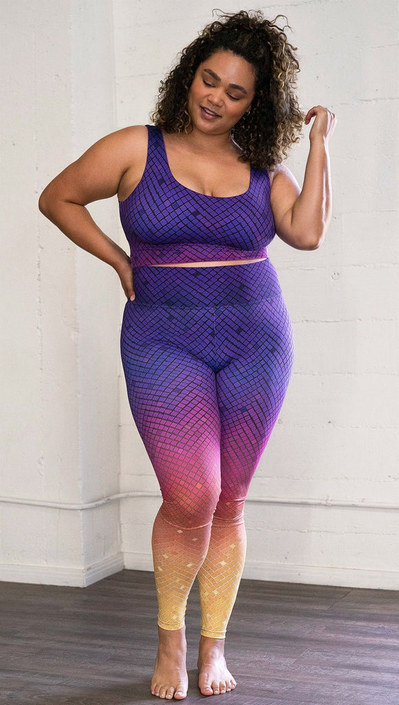 Front view of a model wearing purple/pink/yellow ombre mosaic tile print full length leggings