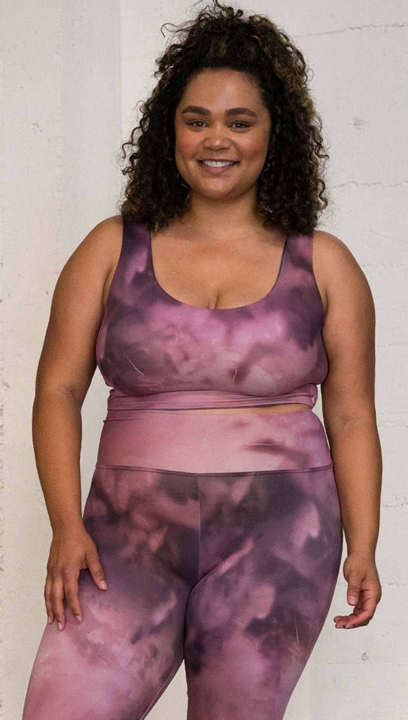 front view of model wearing watercolor inspired reversible tank top with purple on one side and mauve/pink on the other side