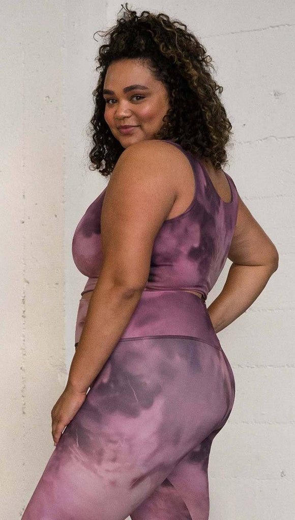 left side view of model wearing watercolor inspired reversible tank top with purple on one side and mauve/pink on the other side