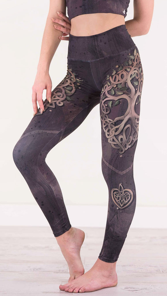 Front view of model wearing the Tree of Life athleisure leggings in a brown wood grain print with a tree on each side