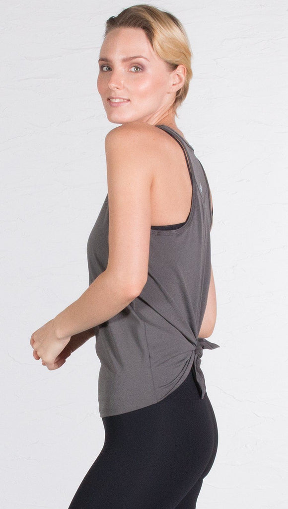 closeup left side view of model wearing gray tie back sports tank top