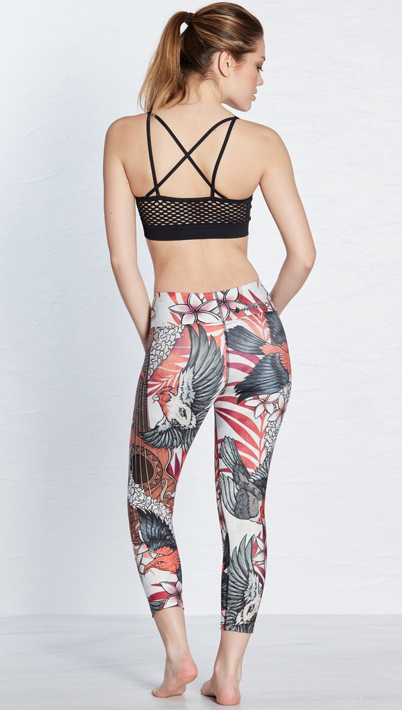 back view of model wearing island bird and ukulele themed printed capri leggings