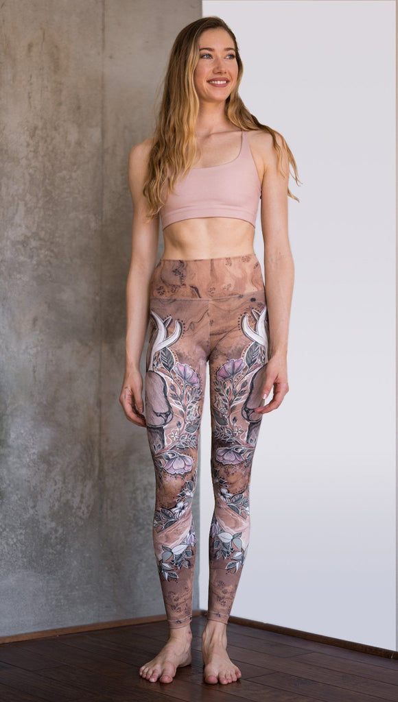 front view of model wearing full length leggings with printed jackalope design