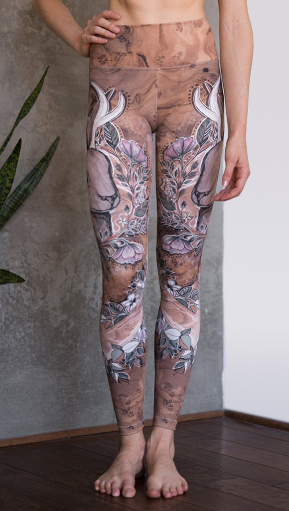 closeup front view of model wearing full length leggings with printed jackalope design