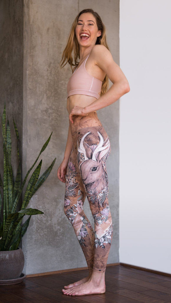 left side view of model wearing full length leggings with printed jackalope design