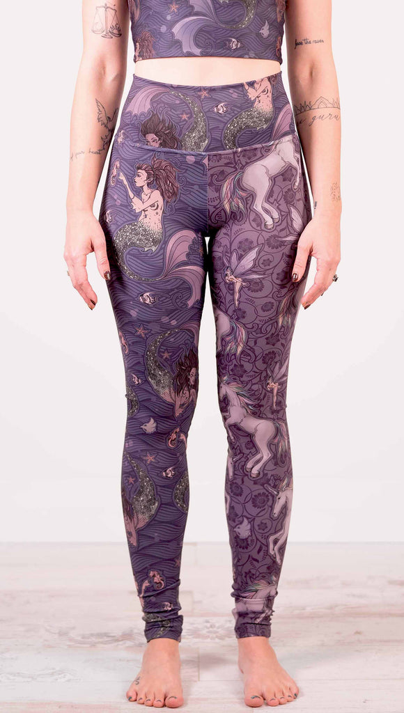 Model wearing WERKSHOP Mermaid and Unicorn Mashup Athleisure Leggings. The leggings feature mermaid artwork on the wearers right leg with a dark blue background and unicorns over a purple background on the wearer's left leg.