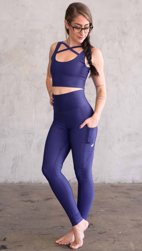 Model wearing WERKSHOP featherlight leggings in solid royal blue color. Leggings have a small reflective eagle logo on the wearer's left pocket.