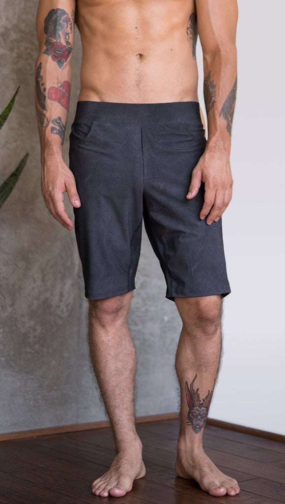 closeup front view of model wearing charcoal black printed mens performance shorts