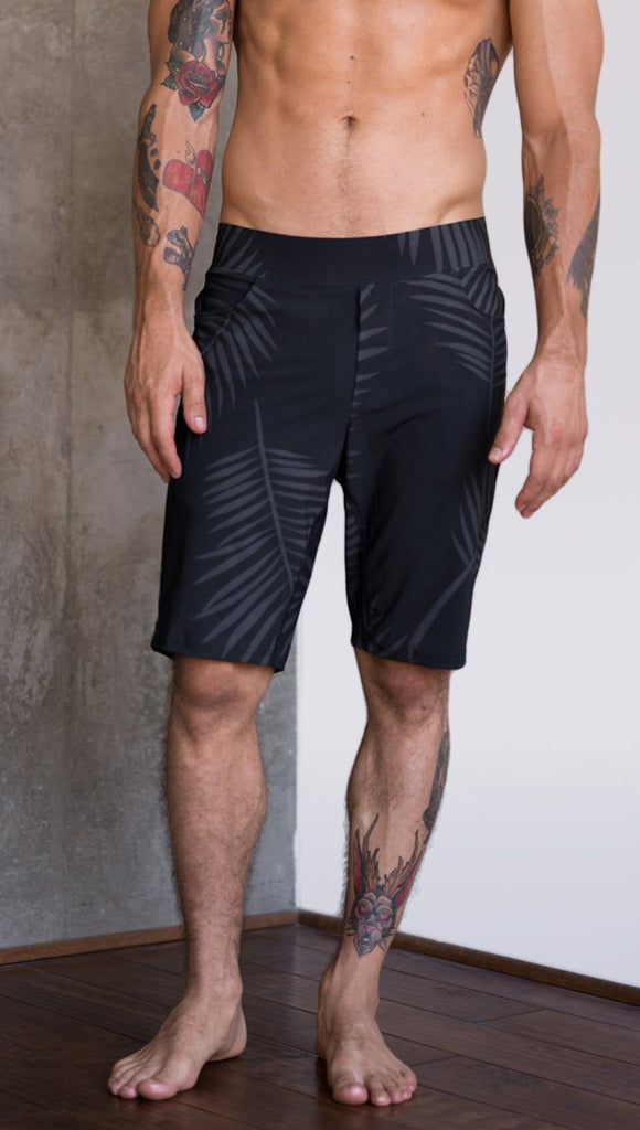 front view of model wearing tropical palm fronds printed mens performance shorts