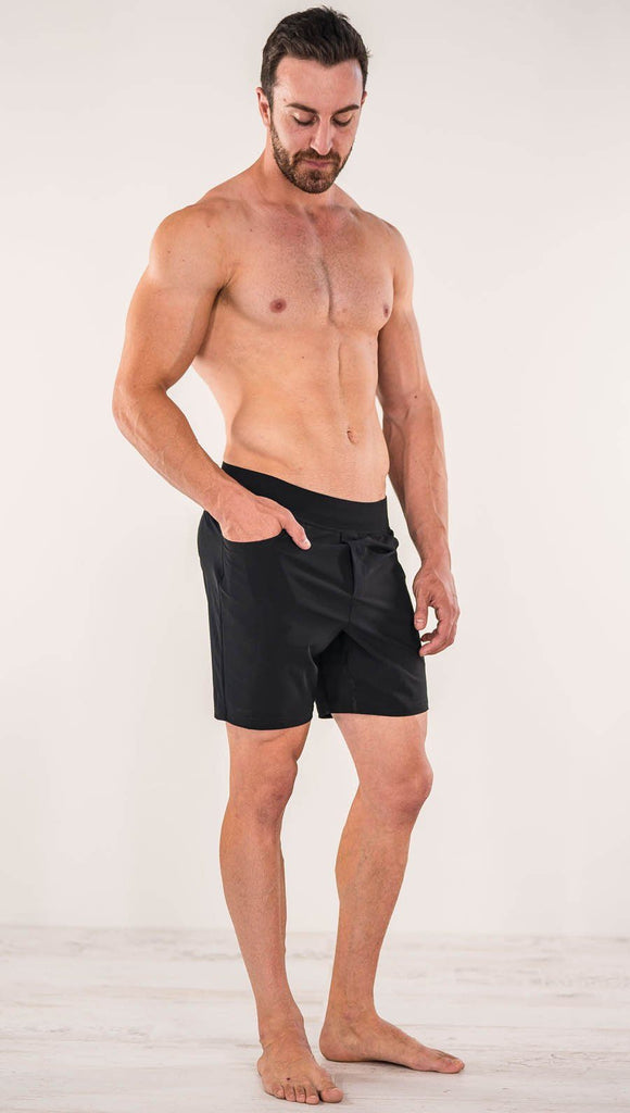 Right side view of model wearing black men's performance shorts