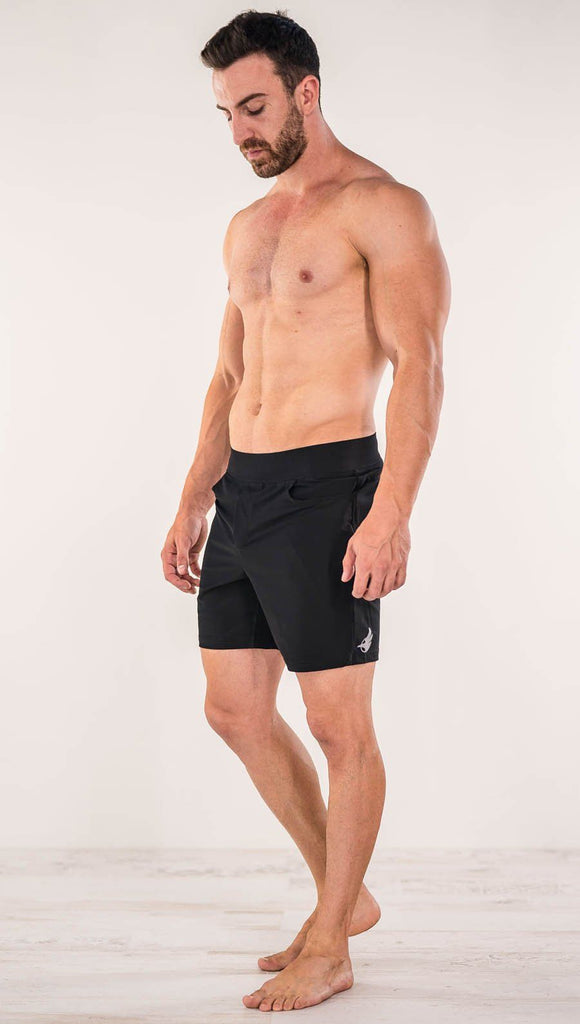 Right side view of model wearing black men's performance shorts