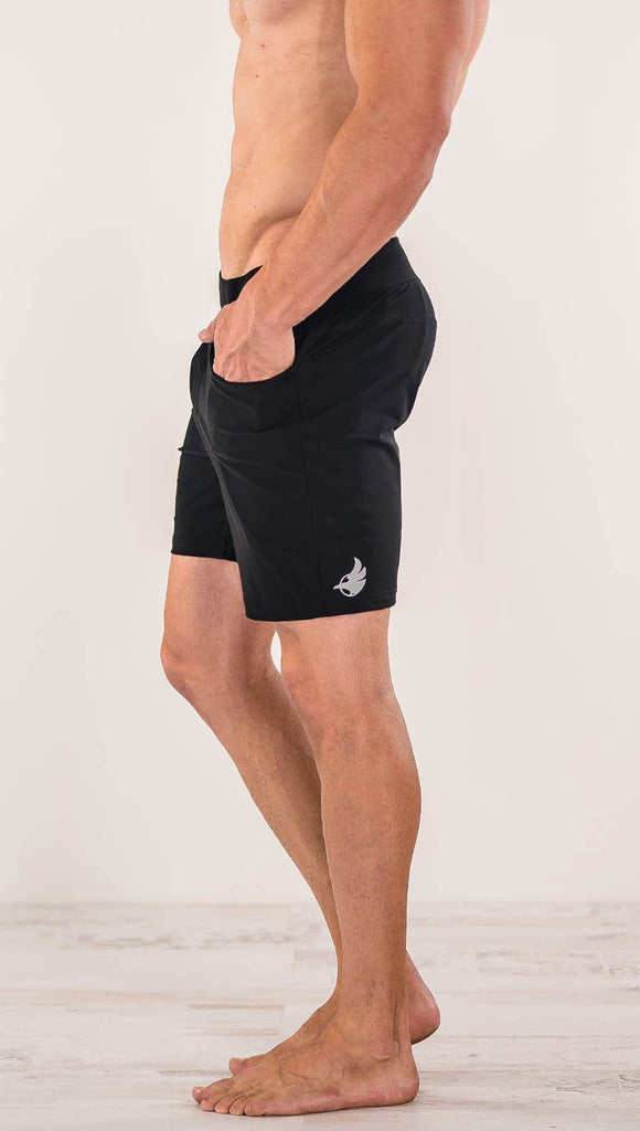 Close up right side view of model wearing black men's performance shorts