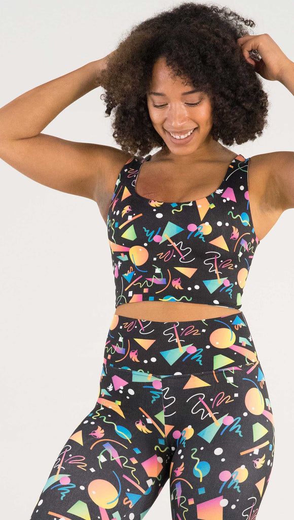 Front view of model wearing WERKSHOP Black and White Confetti Top ... with multi-colored confetti  over a black background on one side and over a white background on the other side. 