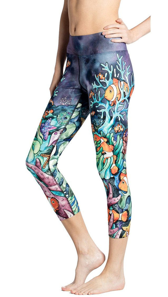 close up side view of model wearing coral reef themed printed capri leggings