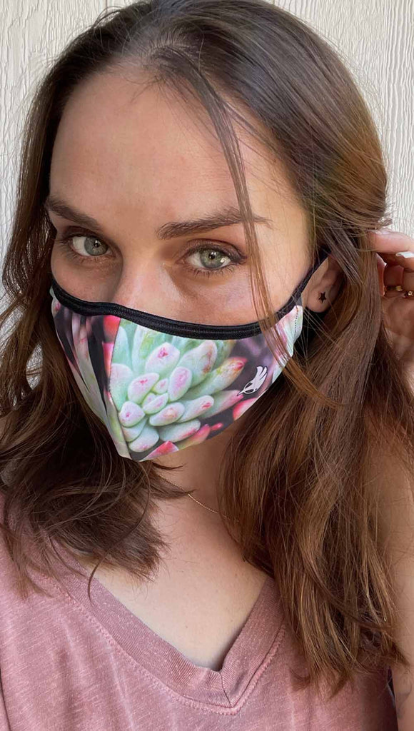 Girl wearing coachella sunset adjustable face mask with bright succulent inspired print - featuring bright green and hot pink tones