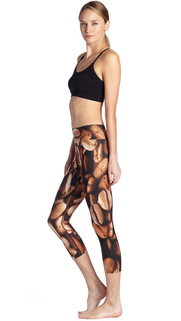 left side view of model wearing coffee bean themed printed capri leggings