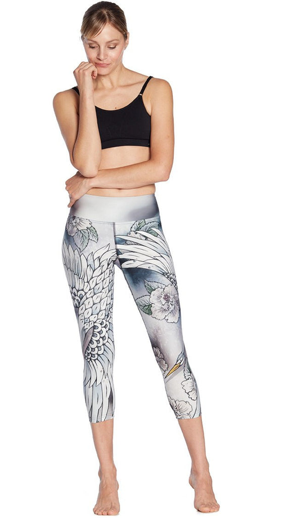 front view of model wearing flying crane themed printed capri leggings