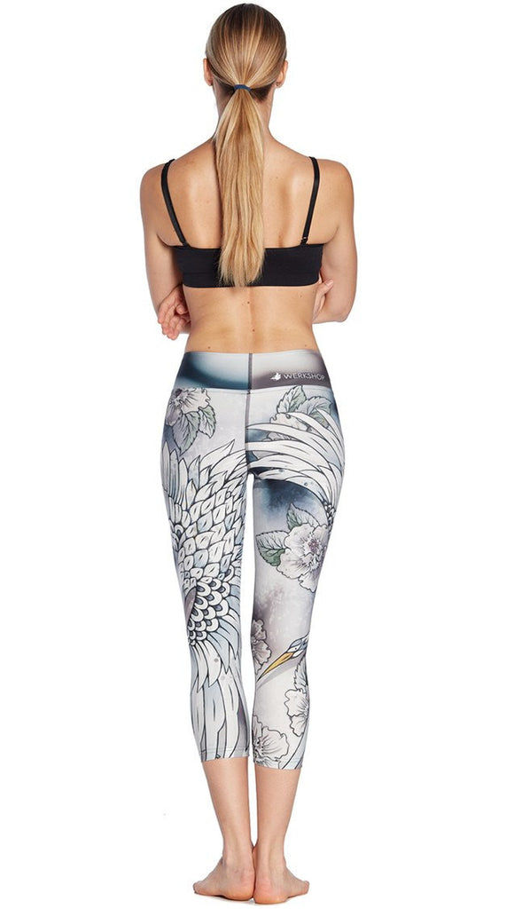 back view of model wearing flying crane themed printed capri leggings