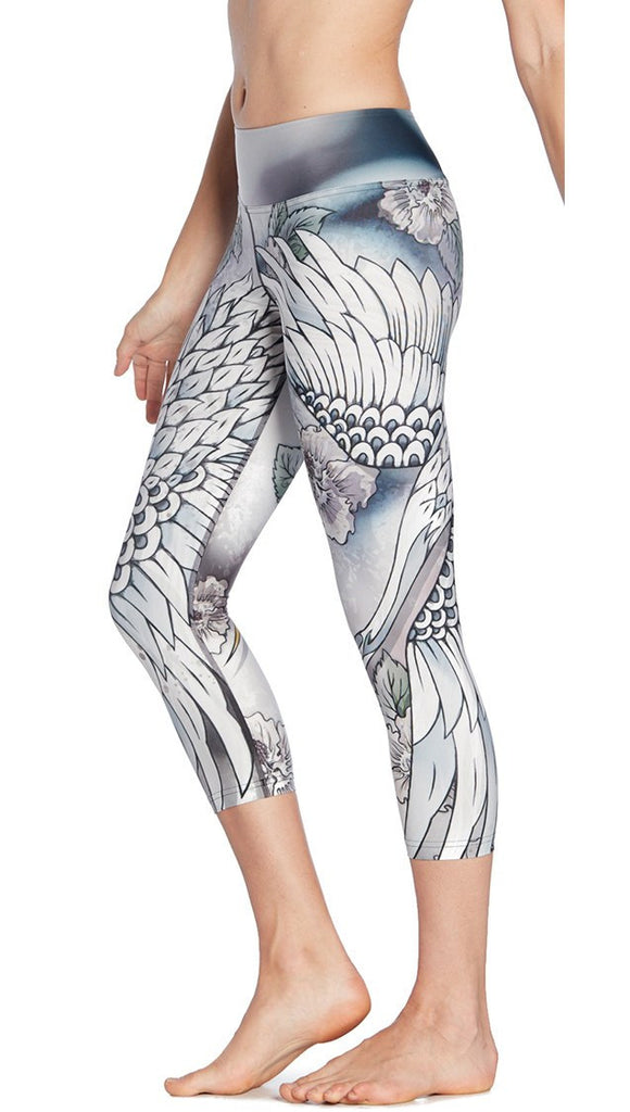 close up left side view of model wearing flying crane themed printed capri leggings