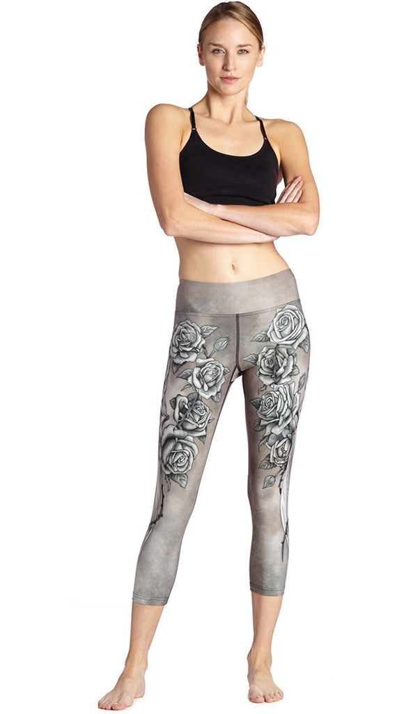 close up side view of model wearing sword and roses themed printed capri leggings