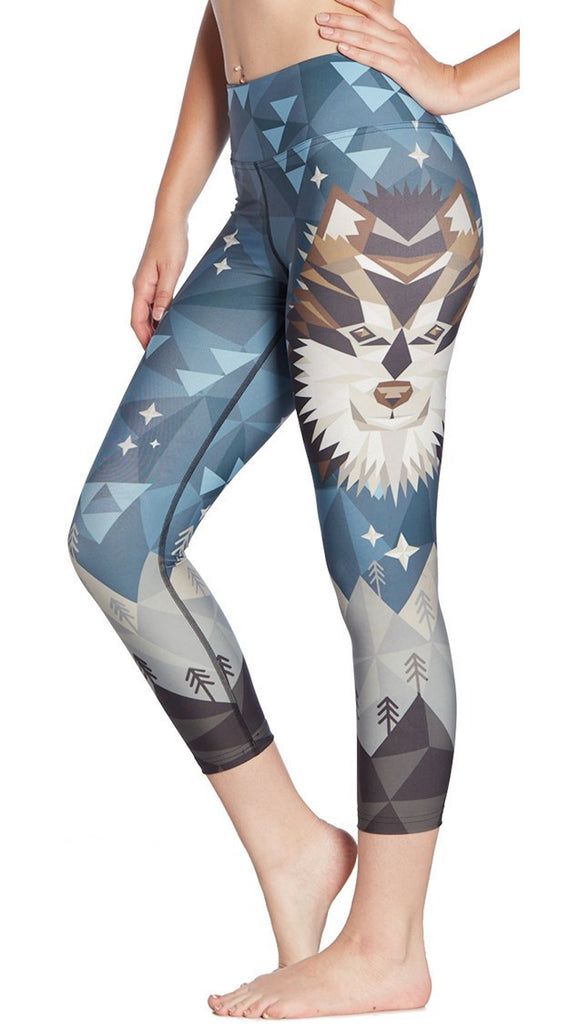 close up side view of model wearing geometric wolf / dog face printed capri leggings