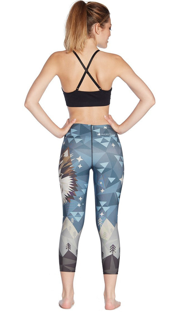 back view of model wearing geometric wolf / dog face printed capri leggings