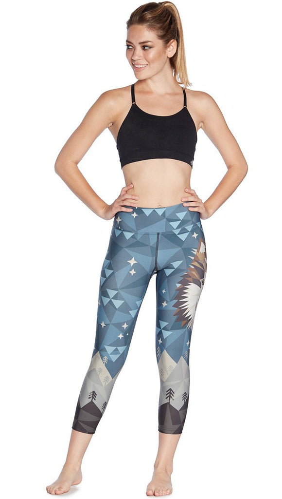 front view of model wearing geometric wolf / dog face printed capri leggings