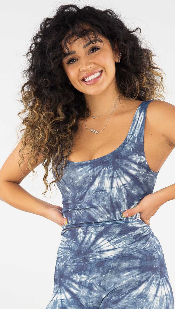 Front view of model wearing the reversible indigo waves/ spiral crop top. This is the spiral side. It is in a indigo color and has white tie dye spirals throughout the top.