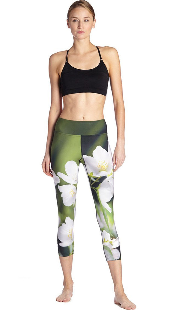 front view of model wearing white jasmine flower themed printed capri leggings