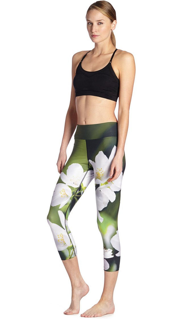 front view of model wearing white jasmine flower themed printed capri leggings