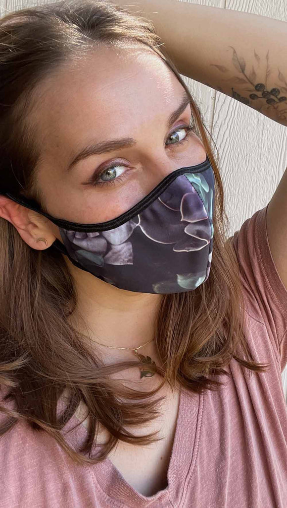 Girl wearing midnight garden adjustable face mask with succulent inspired print - with soft purple and green tones