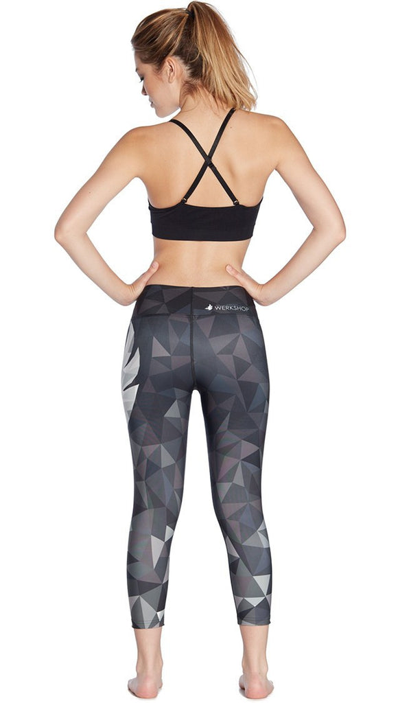 back view of ombre black polygon themed printed capri leggings with large eagle logo motif