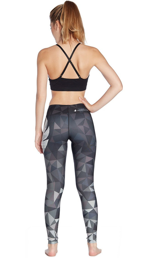 back view of model wearing ombre black polygon themed printed full length leggings with large eagle logo motif