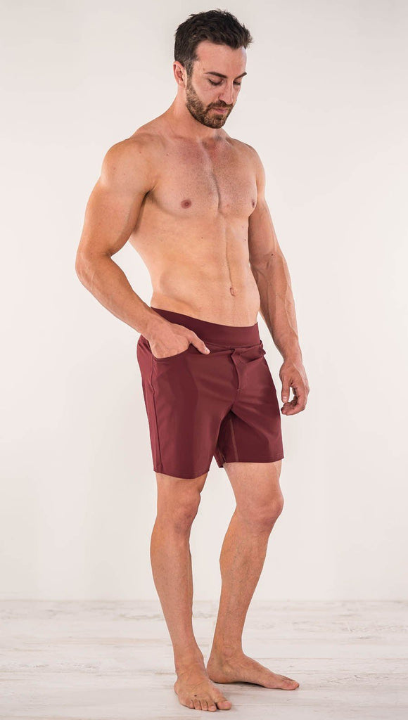 Close up right side view of model wearing men's oxblood performance shorts with slim fit