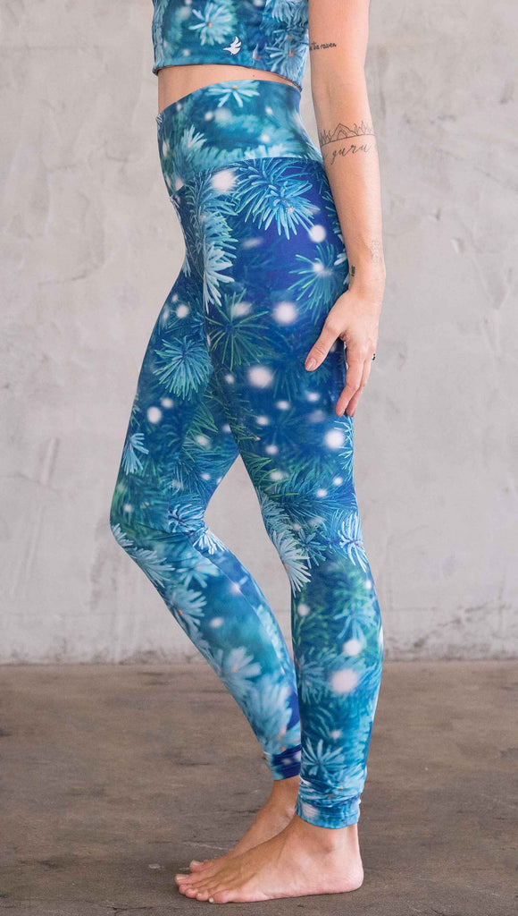 Enhanced left view of model wearing blue leggings with flocked pine