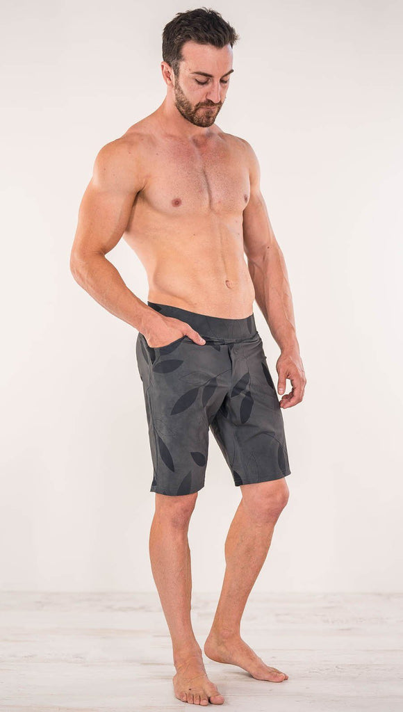 Right side view of model wearing gray printed performance shorts with slim fit and vilva leaf inspired art