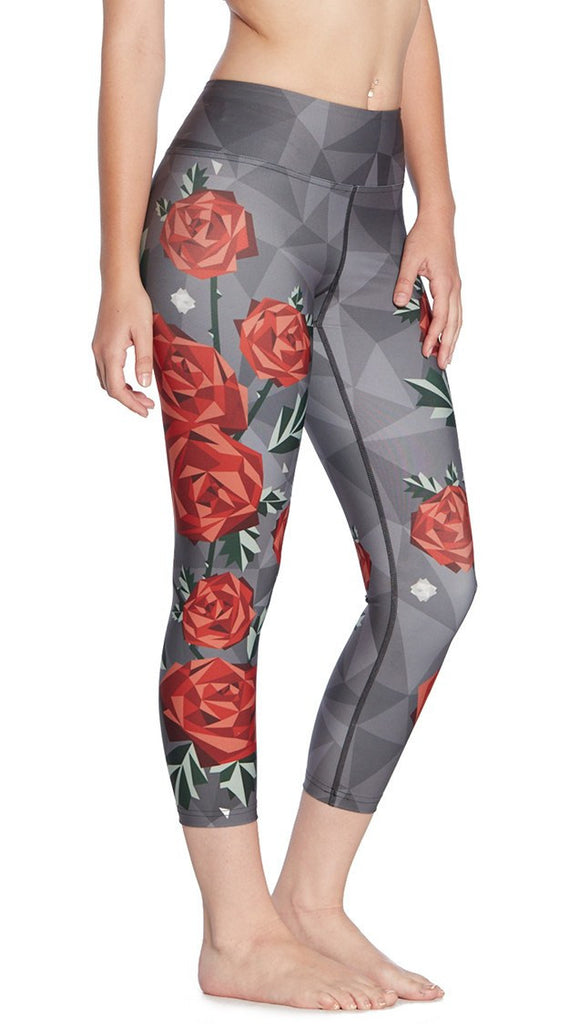 close up right side view of model wearing geometric roses themed printed capri leggings