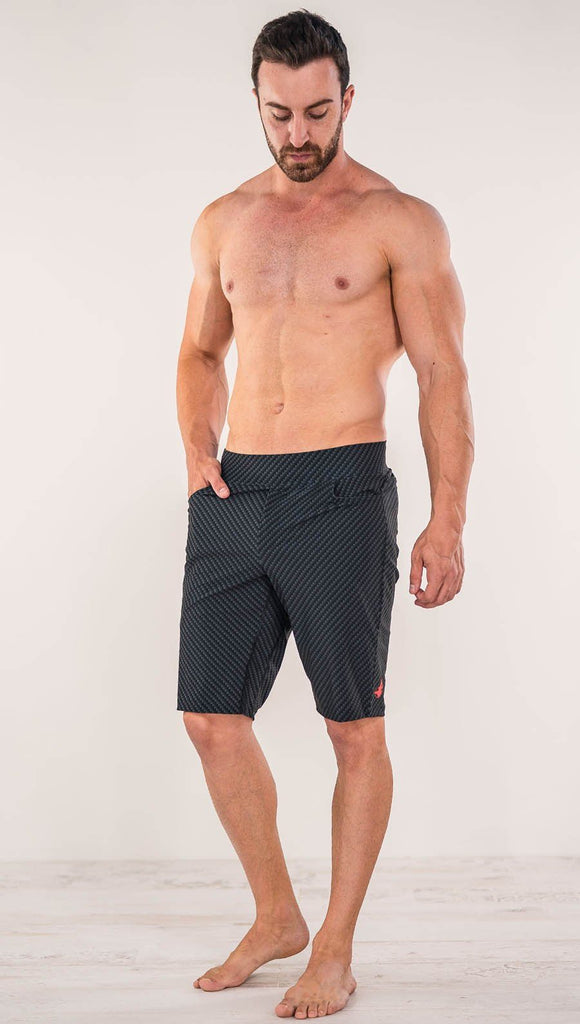 Front view of model wearing men's black printed performance shorts with slim fit and carbon fiber inspired art.