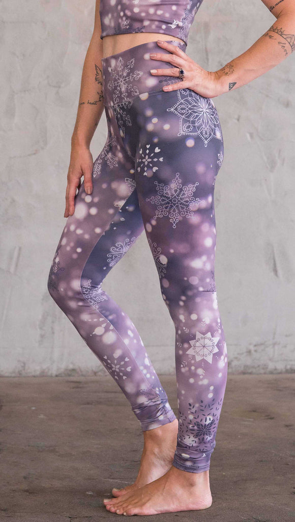 Enhanced left view of model wearing purple leggings with white snowflakes