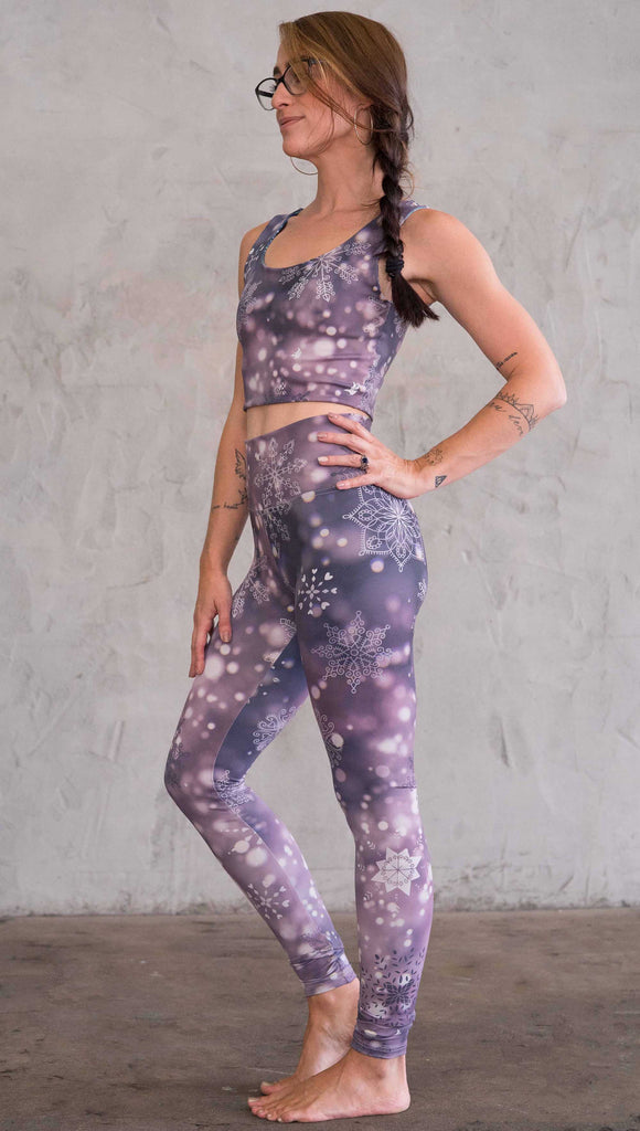 Left view of model wearing purple leggings with white snowflakes