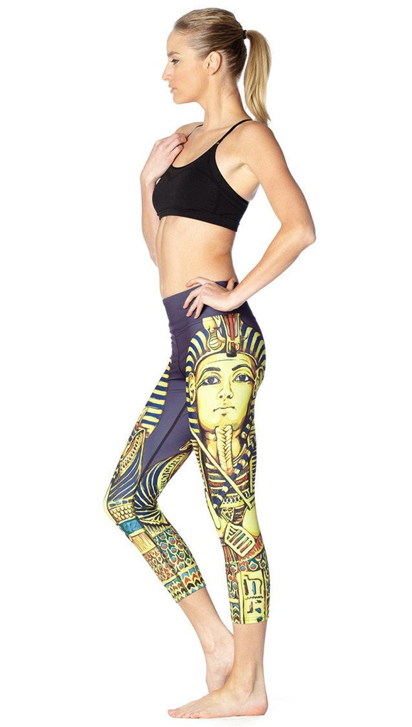 left side view of model wearing King Tut themed printed capri leggings