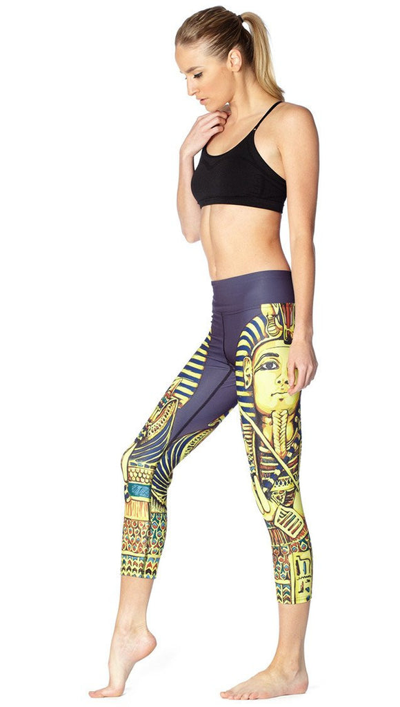 left side view of model wearing King Tut themed printed capri leggings